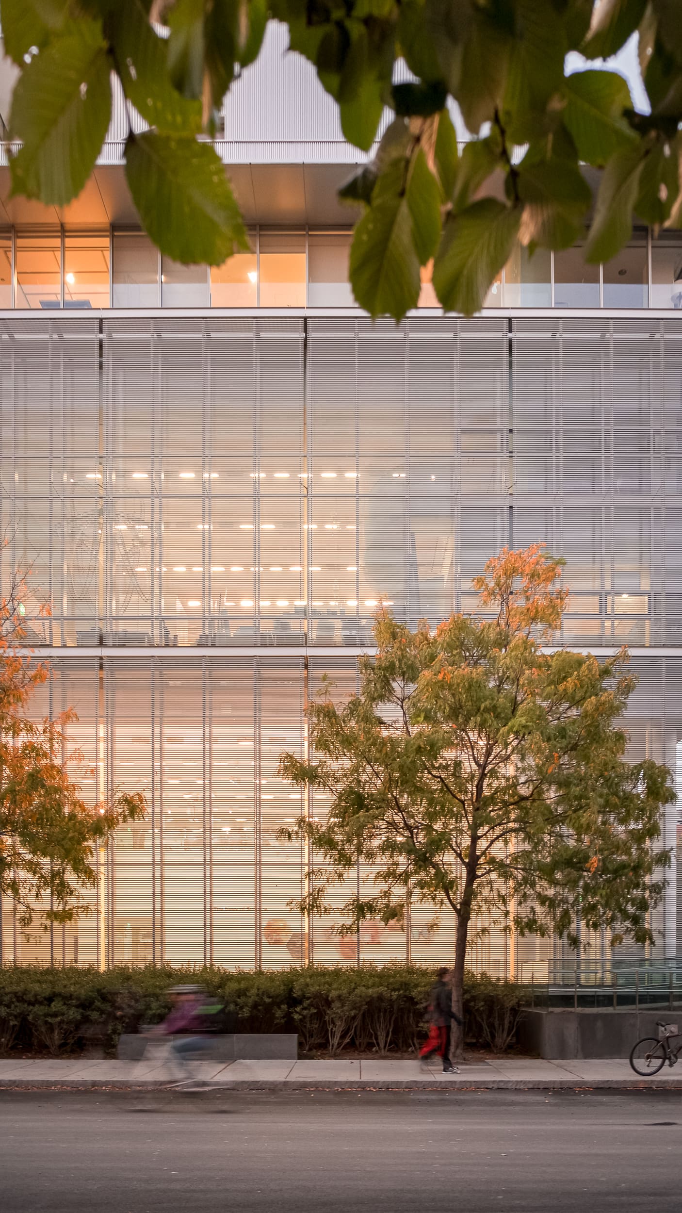 Architectural photography of the MIT Media Lab in Boston Massachusetts designed by Fumihiko Maki and Associates featuring a one point perspective vignette of the space with a bicyclist and pedestrians passing by