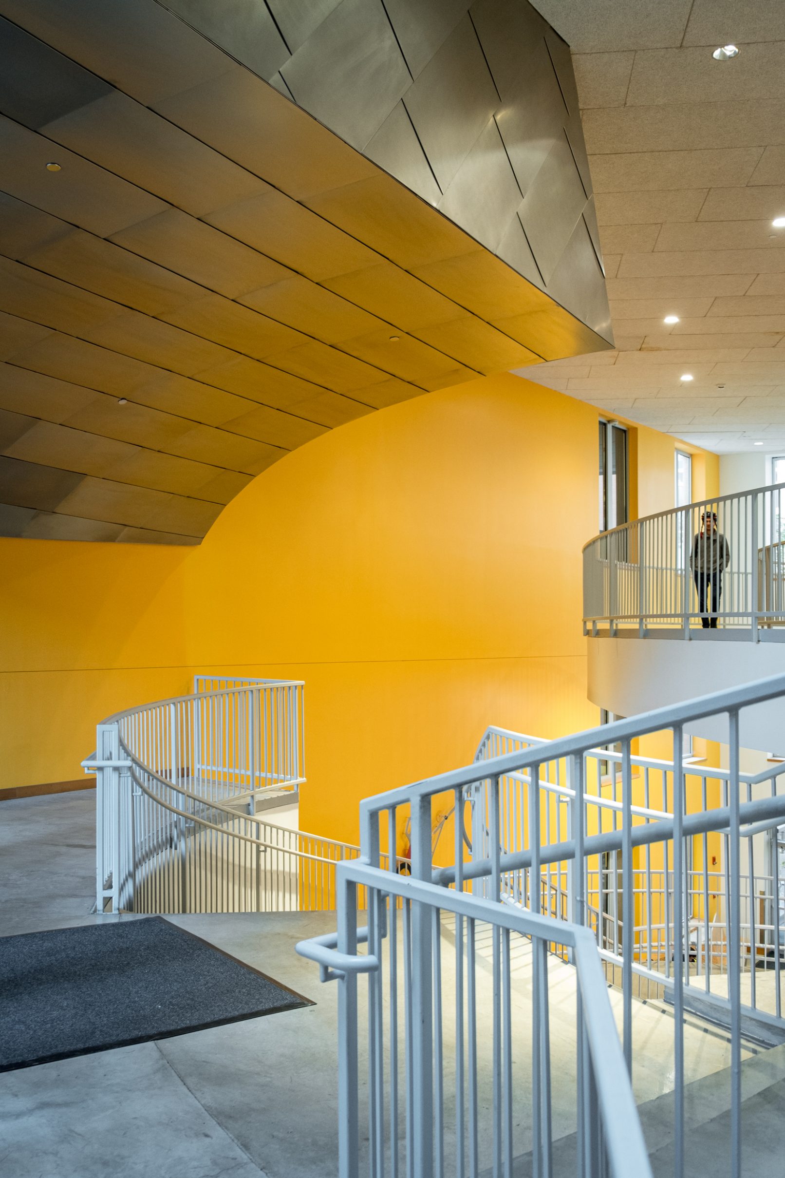 Architectural photography of the Ray and Maria Stata Center at the Massachusetts Institute of Technology (MIT) in Boston designed by Frank Gehry featuring the interior of the space with yellow walls and an aluminum ceiling