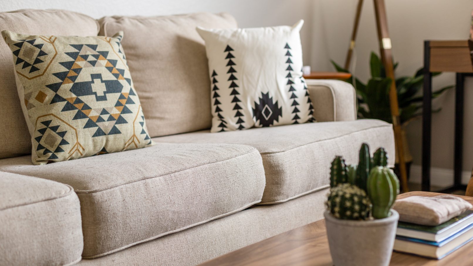 Orange County Interior Design Photography in Fullerton showcasing the details of a cream couch with Aztec inspired pillows and a small cactus on the coffee table